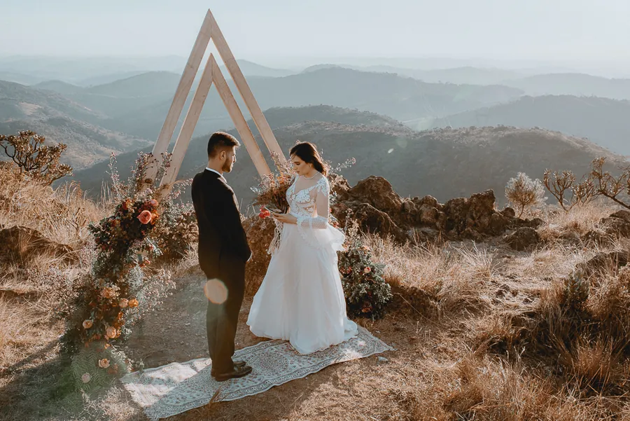 Casamento ao ar livre na serra com arco de madeira, em Minas Gerais